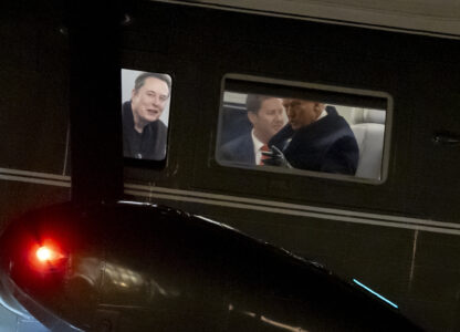 FILE - Elon Musk, left, and President Donald Trump, right, are seen through the windows as Marine One lands on the South Lawn of the White House, Feb. 19, 2025, in Washington. (AP Photo/Alex Brandon, File)
