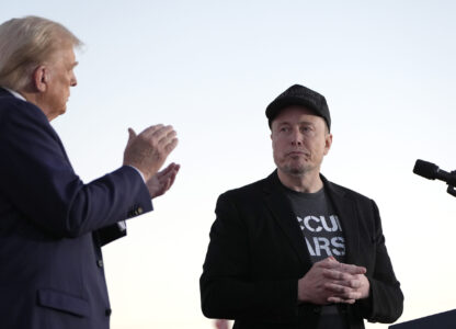 FILE - Republican presidential nominee former President Donald Trump, left, claps as Tesla and SpaceX CEO Elon Musk prepares to depart after speaking at a campaign event at the Butler Farm Show, on Oct. 5, 2024, in Butler, Pa. (AP Photo/Alex Brandon, File)