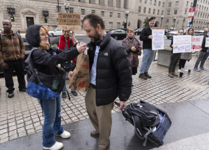United States Agency for International Development (USAID) worker Donato Corsini carries personal belongings after retrieving them from USAID's headquarters in Washington, Thursday, Feb. 27, 2025. (AP Photo/Manuel Balce Ceneta)