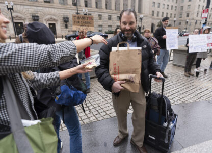 United States Agency for International Development (USAID) worker Donato Corsini carries personal belongings after retrieving them from USAID's headquarters in Washington, Thursday, Feb. 27, 2025. (AP Photo/Manuel Balce Ceneta)
