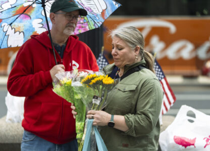 A United States Agency for International Development (USAID) worker holds a bouquet of flowers given to her after retrieving her personal belongings from USAID's headquarters in Washington, Thursday, Feb. 27, 2025. (AP Photo/Manuel Balce Ceneta)