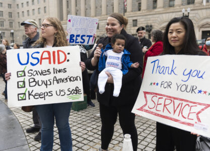 United States Agency for International Development (USAID) supporters hold banners as USAID workers retrieve their personal belongings from the USAID's headquarters in Washington, Thursday, Feb. 27, 2025. (AP Photo/Manuel Balce Ceneta)