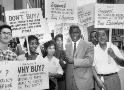 Former baseball star Jackie Robinson holds a sign as he joins a picket line in Cleveland in 1960, to protest discrimination against Blacks at southern lunch counters. (AP Photo/File)