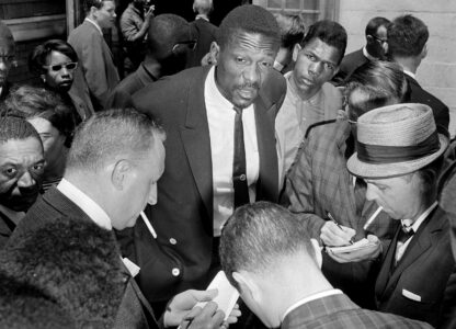 FILE - Boston Celtics star Bill Russell talks with reporters about the boycott of Boston public schools by African Americans, in Boston, on June 18, 1963. Russell spoke to some of the estimated 3,000 children who stayed away from regular classes but attended special sessions called by Black leaders. Children were asked by their parents to stay away from regular classes in protest against what they said was actual if not legal segregation. (AP Photo/Frank Curtin, File)