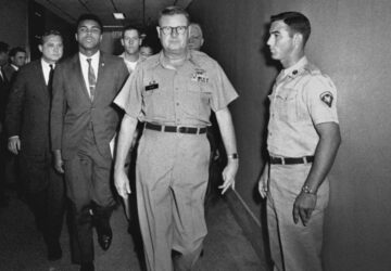 FILE - Heavyweight boxing champion Muhammad Ali is escorted from the Armed Forces Examining and Entrance Station in Houston, on April 28, 1967, by Lt. Col. J. Edwin McKee, commandant of the station, after Ali refused Army induction. Ali says he was a conscientious objector who would not serve in the army of a country that treated members of his race as second-class citizens. (AP Photo/File)