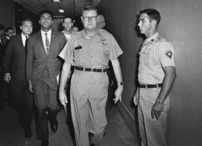 FILE - Heavyweight boxing champion Muhammad Ali is escorted from the Armed Forces Examining and Entrance Station in Houston, on April 28, 1967, by Lt. Col. J. Edwin McKee, commandant of the station, after Ali refused Army induction. Ali says he was a conscientious objector who would not serve in the army of a country that treated members of his race as second-class citizens. (AP Photo/File)
