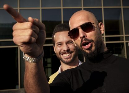 FILE - Andrew Tate gestures, next to his brother Tristan, outside the Bucharest Tribunal in Bucharest, Romania, Thursday, Jan. 9, 2025. (AP Photo/Vadim Ghirda)