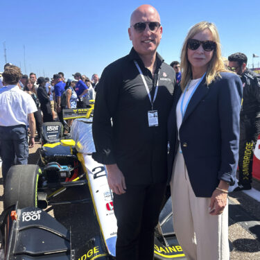 Dan Towriss, the new owner of Andretti Global, and Jill Gregory, president of Andretti Global, stand in front of Colton Herta's race car before the season-opening race, Sunday, March 2, 2025, in St. Petersburg, Fla. (AP Photo/Jenna Fryer)