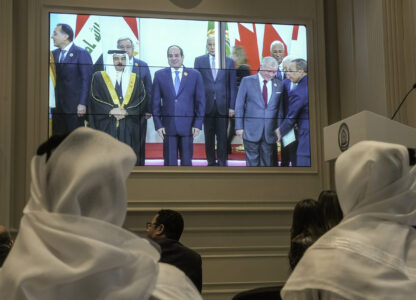 Journalists watch a screen displaying Egyptian President Abdel Fattah el-Sissi, center, with Arab Leaders, at the press center hall of the emergency Arab summit at Egypt's New Administrative Capital, just outside Cairo, Tuesday, March 4, 2025. (AP Photo/Amr Nabil)