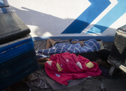 Beverage vendors sleep on a sidewalk before the start of the Heaven on Earth pre-Carnival street party, in Rio de Janeiro, Saturday, Feb. 22, 2025. (AP Photo/Bruna Prado)