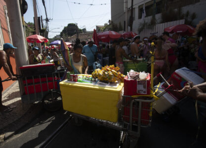 Vendors push Styrofoam coolers through a crowd of revelers at the Heaven on Earth pre-Carnival street party, in Rio de Janeiro, Saturday, Feb. 22, 2025. (AP Photo/Bruna Prado)