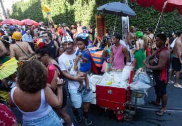 Revelers mill about as vendors with coolers filled with ice cold drinks wait for customers at the Heaven on Earth pre-Carnival street party, in Rio de Janeiro, Saturday, Feb. 22, 2025. (AP Photo/Bruna Prado)