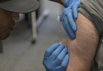Matt Caldwell, left, a Lubbock Fire Department official, administers a measles, mumps and rubella vaccine to Clair May, 61, at the Lubbock Health Department, Wednesday, Feb. 26, 2025, in Lubbock, Texas. (AP Photo/Mary Conlon)