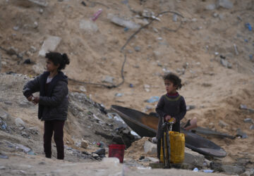 Displaced Palestinians girls fill a plastic jerrycan with water at a school run by UNRWA, the U.N. agency helping Palestinian refugees, which they use as a shelter west of Gaza City, Sunday, March 9, 2025. (AP Photo/Jehad Alshrafi)