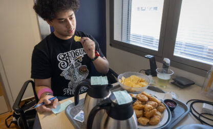 College student and research subject Sam Srisatta eats a lunch of chicken nuggets and chips in his room during a study on the health effects of ultraprocessed foods at the National Institutes of Health in Bethesda, Md., on Thursday, Oct. 31, 2024. (AP Photo/Mark Schiefelbein)