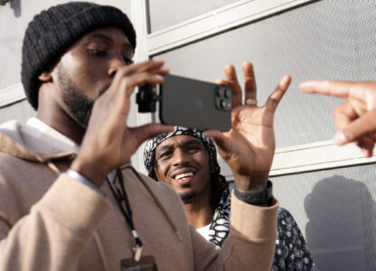 Retired NFL player T.J. Wright, center, watches footage on NFL player Charles Harris' phone as they film a scene from the film 