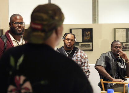 Former and current NFL players, from left, Reginald Kahlil McKenzie, Dion Dawkins and Tevaughn Campbell listen to filmmaker and former professional basketball player Deon Taylor, foreground, discuss the movie industry during a filmmaking workshop for NFL players on Tuesday, March 4, 2025, in Santa Monica, Calif. (AP Photo/Chris Pizzello)