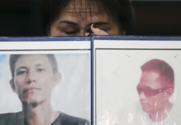 Llore Pasco wipes tears behind pictures of her sons who were victims of alleged extra-judicial killings as she attends a press conference a day after the arrest of former Philippine president Rodrigo Duterte in Quezon City, Philippines on Wednesday, March 12, 2025. (AP Photo/Aaron Favila)