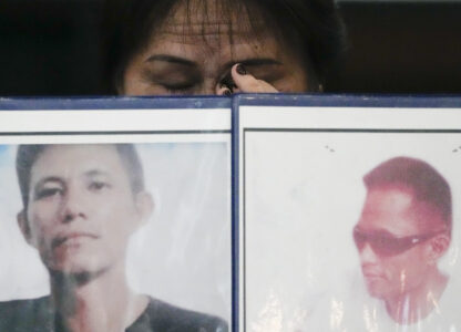 Llore Pasco wipes tears behind pictures of her sons who were victims of alleged extra-judicial killings as she attends a press conference a day after the arrest of former Philippine president Rodrigo Duterte in Quezon City, Philippines on Wednesday, March 12, 2025. (AP Photo/Aaron Favila)