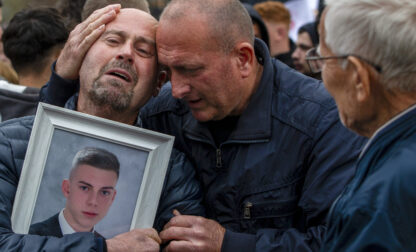 Dragi Stojanov, left, cries holding a photograph of his son Tomche Stojanov, one of the victims of a massive nightclub fire, during a vigil joined by hundreds in the town of Kocani, North Macedonia, Monday, March 17, 2025. (AP Photo/Visar Kryeziu)