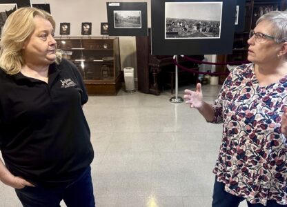 Jackson County Historical Society President Laura Cates Duncan, right, and Mary Riseling, a society board member and coordinator of the 100th anniversary commemoration of the Tri-State Tornado, discuss the March 18, 1925 cataclysm while standing among a gallery of photos on display at the society's office on March 11, 2025 in Murphysboro, Ill. (AP Photo/John O'Connor)