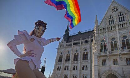 FILE - A participant waves a rainbow flag during an LGBT rights demonstration in front of the Hungarian Parliament building in Budapest, Hungary on June 14, 2021. (AP Photo/Bela Szandelszky, File)