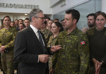 Britain's Prime Minister Keir Starmer speaks to a Canadian Lt Colonel as he visits a military base to meet planners mapping out next steps in the Coalition of the Willing in Northwood, London, Thursday, March 20, 2025.(AP Photo/Alastair Grant, Pool)