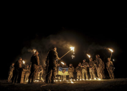 In this photo taken on March 21, 2025 and provided by Ukraine's 24th Mechanized Brigade press service on March 24, 2025, servicemen attend a dedication ceremony for soldiers near the frontline in the Donetsk region, Ukraine. (Oleg Petrasiuk/Ukraine's 24th Mechanized Brigade via AP)