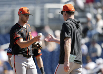 San Francisco Giants manager Bob Melvin, right, takes the ball from Giants starting pitcher Landen Roupp during the fourth inning of a spring training baseball game against the San Diego Padres, Tuesday, March 4, 2025, in Peoria, Ariz. (AP Photo/Ross D. Franklin)