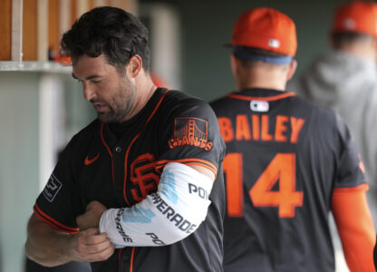 San Francisco Giants starting pitcher Robbie Ray wraps his pitching arm in the dugout during the fourth inning of a spring training baseball game against the Texas Rangers, Thursday, March 13, 2025, in Scottsdale, Ariz. (AP Photo/Ross D. Franklin)