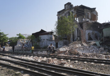 A local man pushes a motorbike past a damaged building following Friday's earthquake in Naypyitaw, Myanmar, Tuesday, April 1, 2025. (AP Photo)