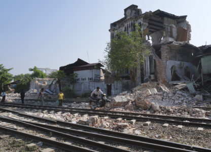 A local man pushes a motorbike past a damaged building following Friday's earthquake in Naypyitaw, Myanmar, Tuesday, April 1, 2025. (AP Photo)