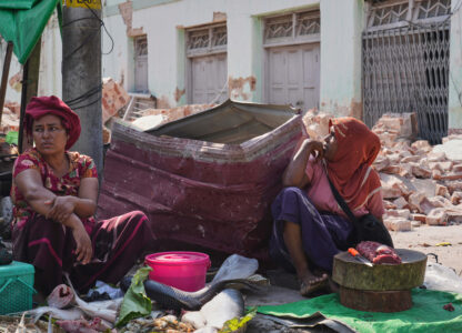 A fish vendor awaits customers at a local bazaar next to damaged buildings following Friday's earthquake in Naypyitaw, Myanmar, Tuesday, April 1, 2025. (AP Photo)