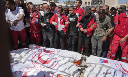 Mourners gather around the bodies of 8 Red Crescent emergency responders, recovered in Rafah a week after an Israeli attack, as they are transported for burial from a hospital in Deir al-Balah, Gaza Strip, on Monday, March 31, 2025. (AP Photo/Abdel Kareem Hana)