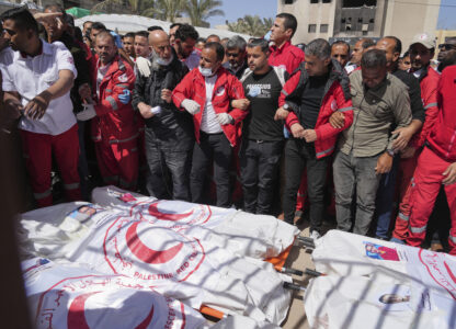 Mourners gather around the bodies of 8 Red Crescent emergency responders, recovered in Rafah a week after an Israeli attack, as they are transported for burial from a hospital in Deir al-Balah, Gaza Strip, on Monday, March 31, 2025. (AP Photo/Abdel Kareem Hana)