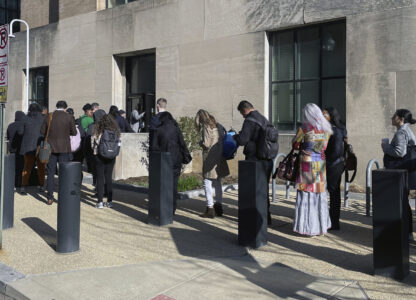 Hundreds of employees wait in line wrapped around the outside of the Health and Human Services headquarters building, Tuesday morning, April 1, 2025 in Washington. (AP Photo/Amanda Seitz)