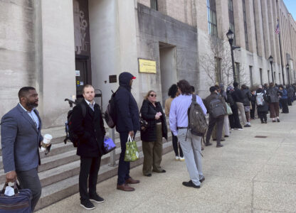 Hundreds of employees wait in line wrapped around the outside of the Health and Human Services headquarters building, Tuesday morning, April 1, 2025 in Washington. (AP Photo/Amanda Seitz)