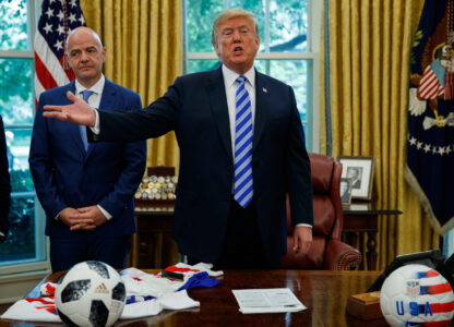FILE - FIFA president Gianni Infantino, left, watches as President Donald Trump speaks to reporters during a meeting in the Oval Office of the White House, Aug. 28, 2018, in Washington. (AP Photo/Evan Vucci, File)