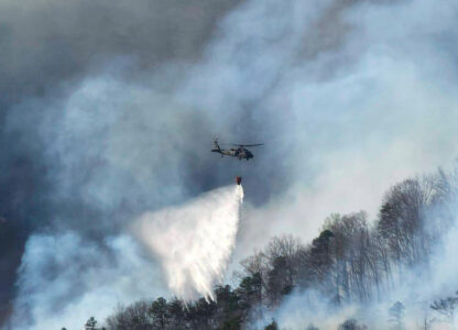 In this March 23, 2025, photo released by the U.S. National Guard shows a UH-60 Black Hawk helicopter from the 1-111th General Support Aviation Battalion, 59th Aviation Troop Command, McEntire Joint National Guard Base in Eastover executing its fire suppression mission in support of the South Carolina Forestry Commission at Persimmon Ridge Fire near Greenville, S.C. (Sgt. 1st Class Roberto Di Giovine/U.S. Army National Guard via AP)