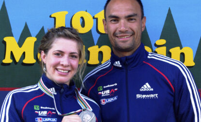 FILE - In this 2009 photo provided by Karen Gorman, biathlete Grace Boutot, left, of Fort Kent, Maine, displays her silver medal from the Youth Women Biathlon World Championships, while standing with coach Gary Colliander, right, in Fort Kent. (Karen Gorman via AP, File)
