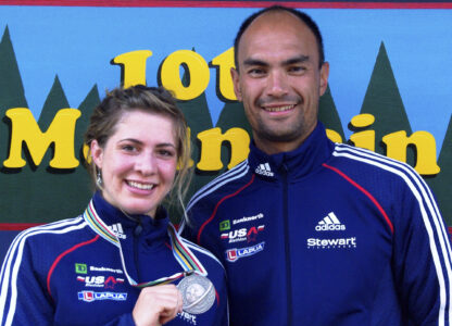 FILE - In this 2009 photo provided by Karen Gorman, biathlete Grace Boutot, left, of Fort Kent, Maine, displays her silver medal from the Youth Women Biathlon World Championships, while standing with coach Gary Colliander, right, in Fort Kent. (Karen Gorman via AP, File)
