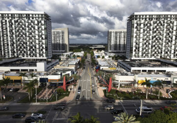 Cars pass through the area known as Downtown Doral, Saturday, April 5, 2025, in Doral, Fla. (AP Photo/Rebecca Blackwell)