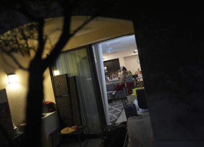 Maria, a Venezuelan immigrant who lives with her U.S. citizen husband and two daughters who have Temporary Protected Status, or TPS, vacuums a rug as the family organizes and packs for their upcoming move into a larger and nicer apartment, Saturday, April 5, 2025, in Doral, Fla. (AP Photo/Rebecca Blackwell)