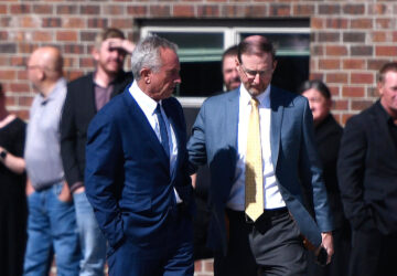 Health and Human Services Secretary Robert F. Kennedy Jr., left, arrives at Reinlander Mennonite Church after a second measles death, Sunday, April 6, 2025, in Seminole, Texas. (AP Photo/Annie Rice)