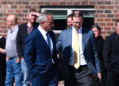 Health and Human Services Secretary Robert F. Kennedy Jr., left, arrives at Reinlander Mennonite Church after a second measles death, Sunday, April 6, 2025, in Seminole, Texas. (AP Photo/Annie Rice)