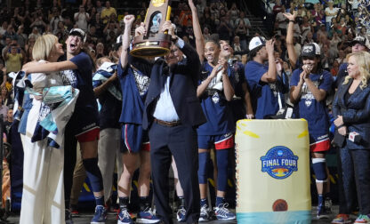 UConn head coach Geno Auriemma holds up the championship trophy after UConn defeated South Carolina in the national championship game at the Final Four of the women's NCAA college basketball tournament, Sunday, April 6, 2025, in Tampa, Fla. (AP Photo/John Raoux)