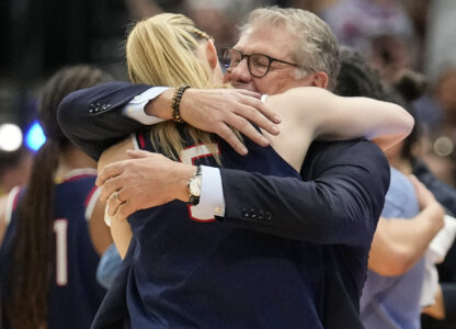UConn head coach Geno Auriemma hugs UConn guard Paige Bueckers (5) as she comes off the floor late in the second half of the national championship game against South Carolina at the Final Four of the women's NCAA college basketball tournament, Sunday, April 6, 2025, in Tampa, Fla. (AP Photo/Chris O'Meara)