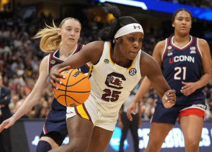 South Carolina guard Raven Johnson (25) drives to the lane against UConn guard Paige Bueckers (5) and forward Sarah Strong (21) during the first half of the national championship game at the Final Four of the women's NCAA college basketball tournament, Sunday, April 6, 2025, in Tampa, Fla. (AP Photo/John Raoux)