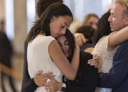 Alessa and Abigale Love hug attendees who came to pay their respects during a funeral service for former U.S. Rep. Mia Love, Sunday, April 6, 2025, in Salt Lake City. (AP Photo/Melissa Majchrzak)