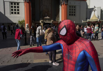 A street performer dressed as Spider Man walks past TCL Chinese Theatre on the Hollywood Walk of Fame in Los Angeles, Friday, April 4, 2025. (AP Photo/Jae C. Hong)